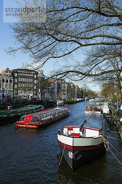 Grachtenfahrt mit typischem Touristen-Boot  Tour  Grachtentour  Städtetour  Tourismus  Städtereise  Urlaub  Reise  Stadterkundung  Stadtführung  Zentrum  Amsterdam  Niederlande  Europa