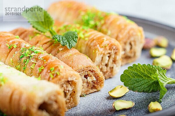 Baklava  traditionelle arabische Süßigkeiten in einem grauen Keramikteller auf einem grauen Betonhintergrund. Seitenansicht  Nahaufnahme  selektiver Fokus