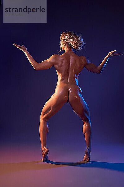 Rückenansicht einer athletischen nackten Frau  die in Waage Pose steht  mit perfekt durchtrainiertem Körper in einem lila Studio