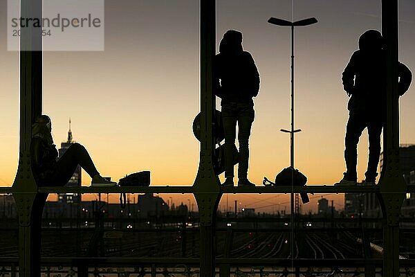 Menschen auf der Hackerbrücke in München bei Sonnenuntergang