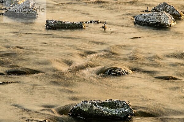 Fließender Fluss über Felsen  aufgenommen im ruhigen Licht der goldenen Stunde  in Südkorea