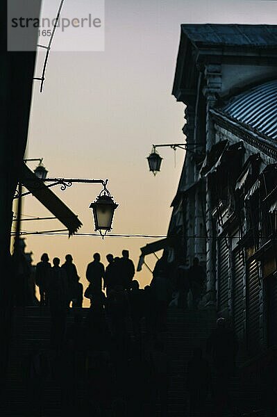 Touristen als Silhouette auf der Rialto-Brücke in der letzten Abendsonne  überlaufen  voll  Städtereise  Urlaub  Reise  Tourismus  Lagunenstadt  historisch  Geschichte  Baugeschichte  Architektur  historisch  berühmt  Attraktion  Bauwerk  Seightseeing  Fassade  Haus  Altbau  gefährdet  Weltkulturerbe  UNESCO  Kultur  Mittelalter  Umwelt  Kreuzfahrt  Venedig  Italien  Europa