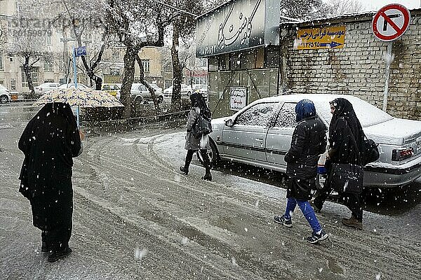 Starker Schneefall in Arak  Iran  Frauen mit Tschador und Regenschirm und traditioneller Kleidung  16.03.2019