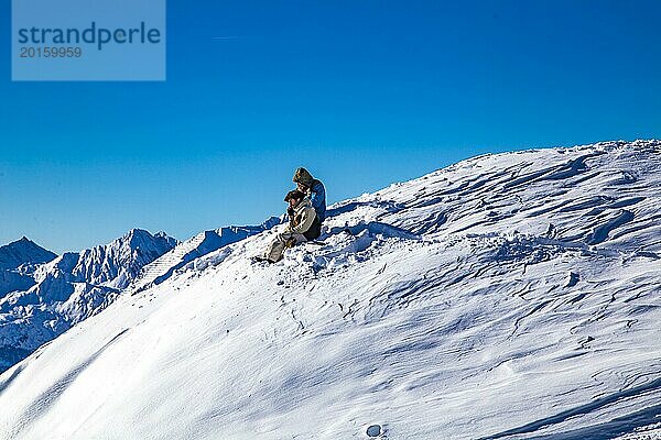 Zwei Snowboarder rasten vor der Abfahrt am Gipfel  Bergstation 150er Tux  Skigebiet Penken  Mayrhofen  Zillertal  Tirol