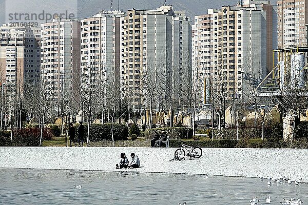 Eine junges Paar sitzt am Strand des Chitgar Sees in Tehran  Iran. Der Chitgar See ist ein künstlich angelegter See im Nordwesten von Teheran  auch als See der Märtyrer des Persischen Golfs bekannt  10.03.2019