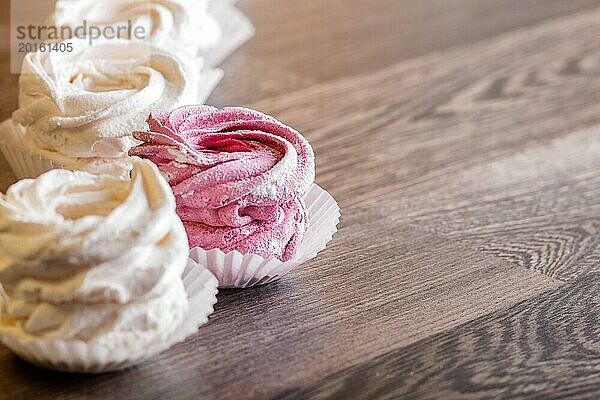 Rosa und weiße hausgemachte Marshmallows auf einem grauen hölzernen Hintergrund. selektiver Fokus