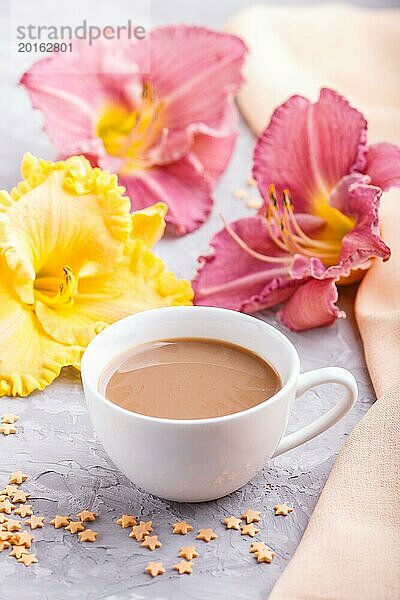 Gelbe und lila Taglilien Tasse Kaffee auf einem grauen Hintergrund Beton  mit orangefarbenen Textil. Morninig  Frühling  Mode Zusammensetzung  Seitenansicht  Nahaufnahme  selektiver Fokus