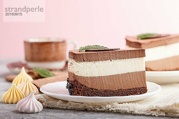 Kuchen mit Souffle Milchschokolade Creme mit Tasse Kaffee auf einem grauen und rosa Hintergrund und Leinen Serviette. Seitenansicht  Nahaufnahme  selektiver Fokus