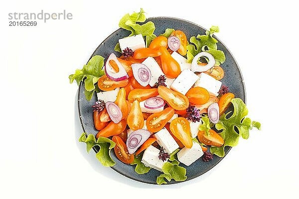 Vegetarischer Salat mit frischen Traubentomaten  Fetakäse  Kopfsalat und Zwiebeln auf blauem Keramikteller vor weißem Hintergrund  Draufsicht  Nahaufnahme  flat lay
