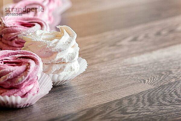 Rosa und weiße hausgemachte Marshmallows auf einem grauen hölzernen Hintergrund. selektiver Fokus