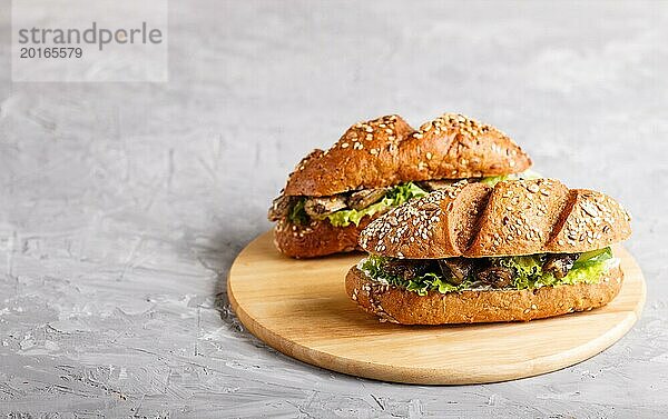 Sprotten Sandwiches mit Salat und Frischkäse auf Holzbrett auf grauem Betonhintergrund. Seitenansicht  Kopierraum  selektiver Fokus