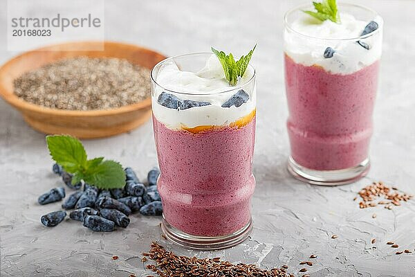 Smoothie mit Geißblatt  Leinen und Chia in einem Glas auf grauem Betonhintergrund. Seitenansicht  Nahaufnahme  selektiver Fokus