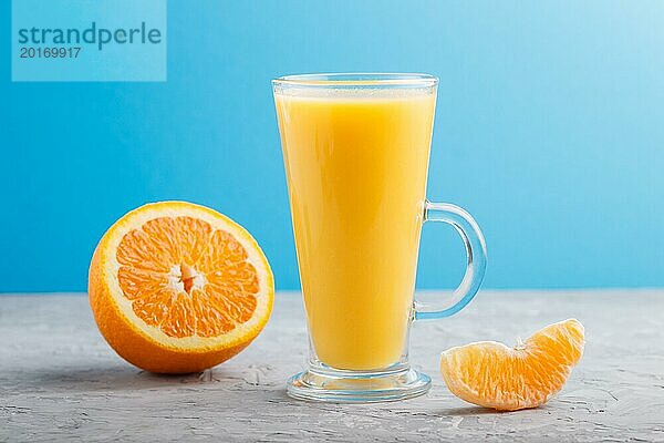 Glas Orangensaft auf einem grauen und blauen Hintergrund. Morninig  Frühling  gesundes Getränk Konzept. Seitenansicht  Nahaufnahme