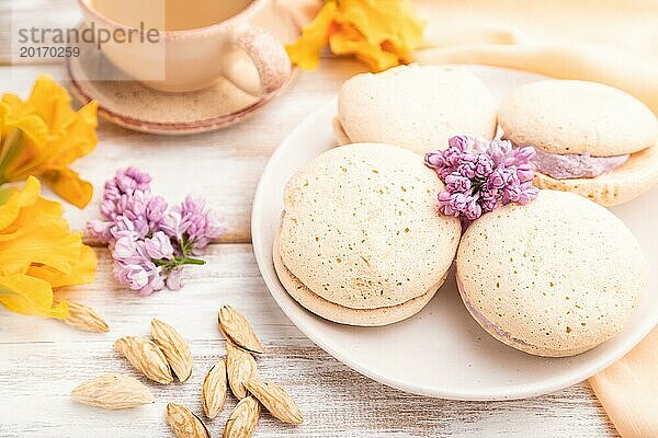 Meringues Kuchen mit einer Tasse Kaffee auf einem weißen Holzhintergrund und orangefarbenem Leinenstoff. Seitenansicht  Nahaufnahme  selektiver Fokus