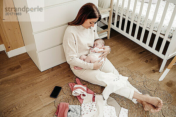 Mutter mit kleinem Mädchen  das zu Hause in der Nähe des Kinderbetts schläft