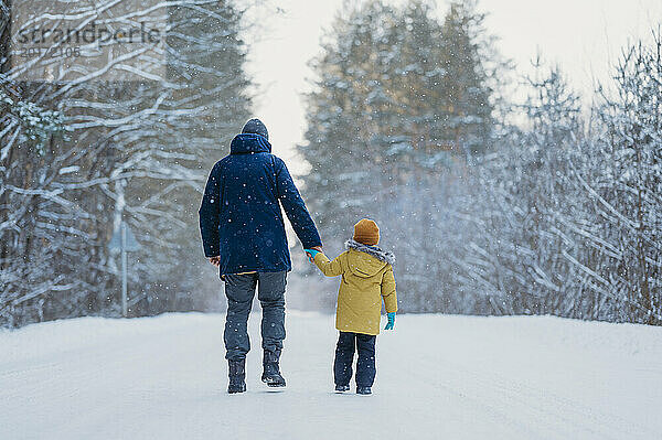 Vater und Sohn gehen im Winterwald spazieren