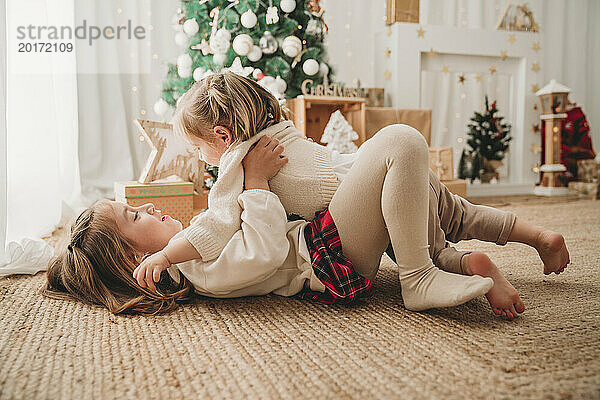 Fröhliche Mädchen spielen und genießen die Weihnachtsdekoration
