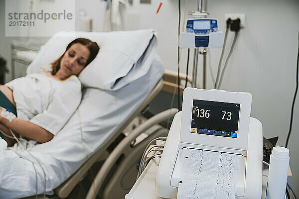 Überwachungsgeräte in der Nähe einer schwangeren Frau  die im Krankenhaus auf dem Bett liegt