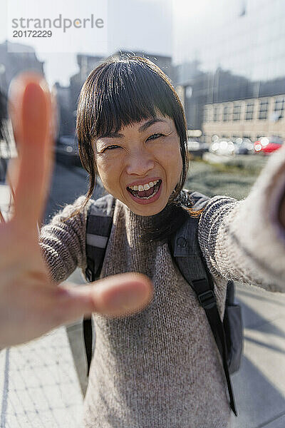 Happy woman waving and talking on video call