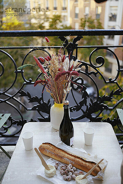 Vase mit Weinflasche und Essen auf dem Balkon
