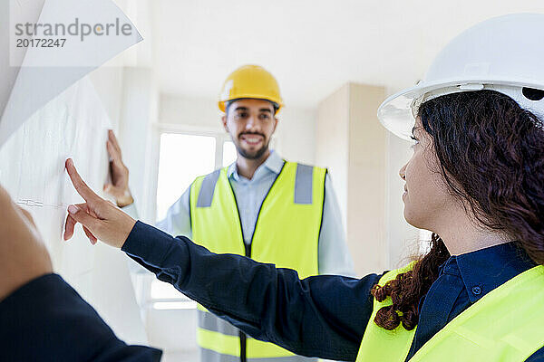 Architekten diskutieren über Bauplan auf der Baustelle