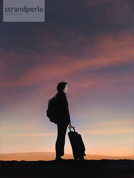 Junge Frau reist mit Gepäck bei Sonnenuntergang