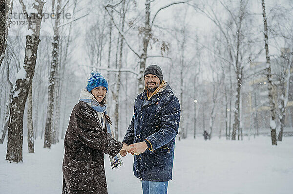 Glückliches Paar hält Händchen im Snowpark