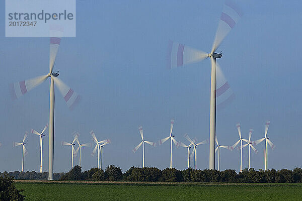 Wind turbines spinning against sky
