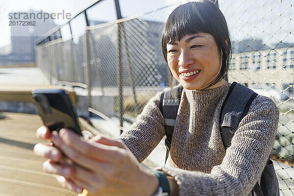 Smiling mature woman using smart phone