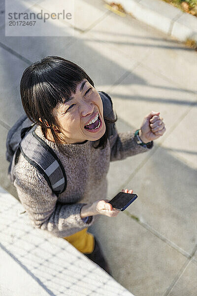 Cheerful woman walking with smart phone