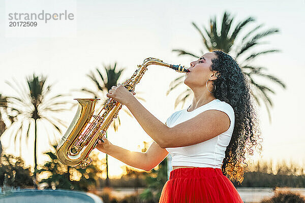 Leidenschaftliche Frau spielt Saxophon im Skatepark
