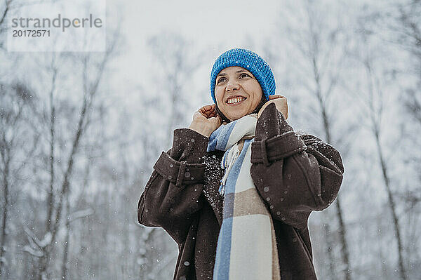 Lächelnde Frau mit Strickmütze im Winter