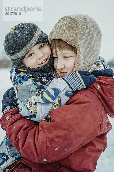 Nette Brüder  die sich im Schnee umarmen