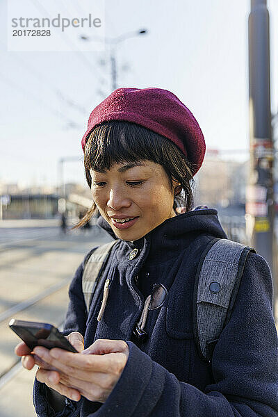 Reife Frau benutzt Smartphone an sonnigem Tag
