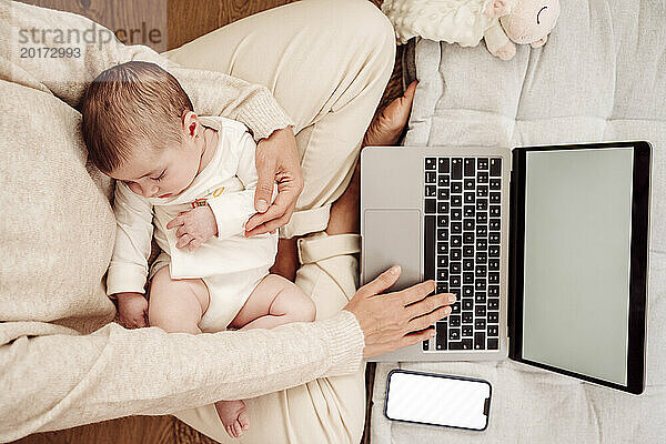 Freiberufler arbeitet am Laptop  während seine kleine Tochter zu Hause schläft