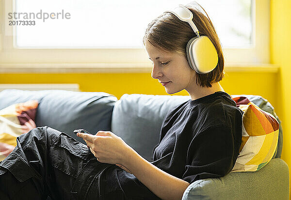 Mädchen hört zu Hause Musik über kabellose Kopfhörer