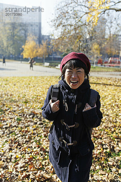 Cheerful mature woman in autumn park