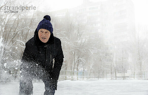 Älterer Mann in warmer Kleidung steht im Park