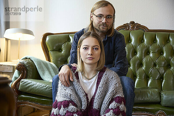 Frau und Mann sitzen zu Hause auf dem Sofa