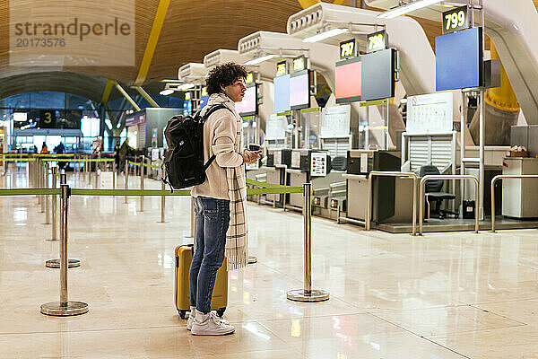 Mann mit Gepäck wartet am Flughafen auf Flug