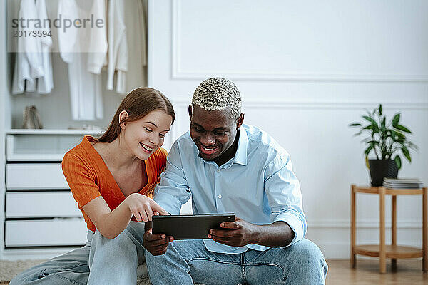 Glücklicher Mann und Frau  die zu Hause einen Tablet-PC nutzen