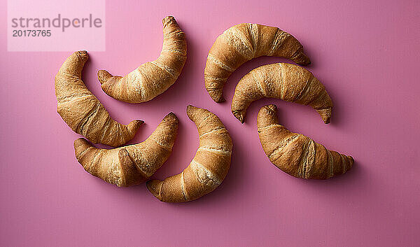 Studioaufnahme von hausgemachten Croissants auf rosa Hintergrund