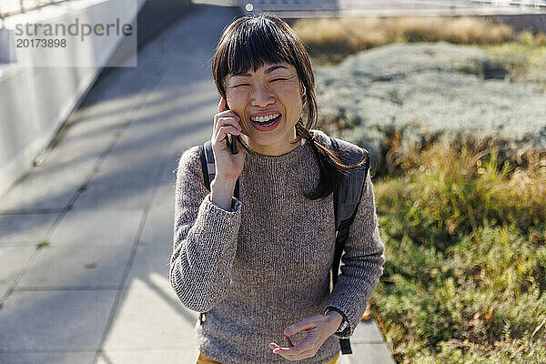 Fröhliche reife Frau  die auf dem Smartphone spricht