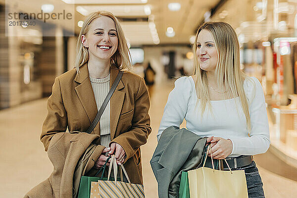 Glückliche Freunde  die Papiertüten im Einkaufszentrum tragen