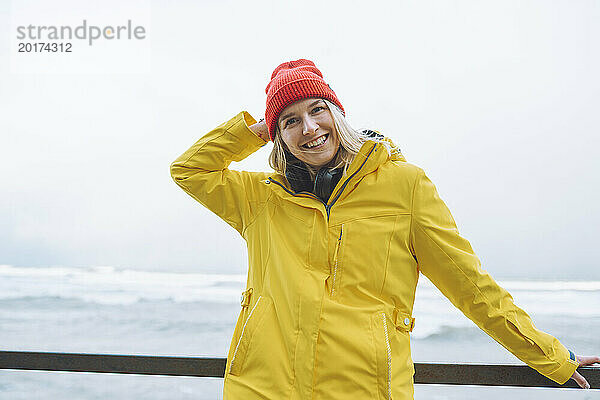 Glückliche junge Frau in Winterjacke auf dem Seeweg