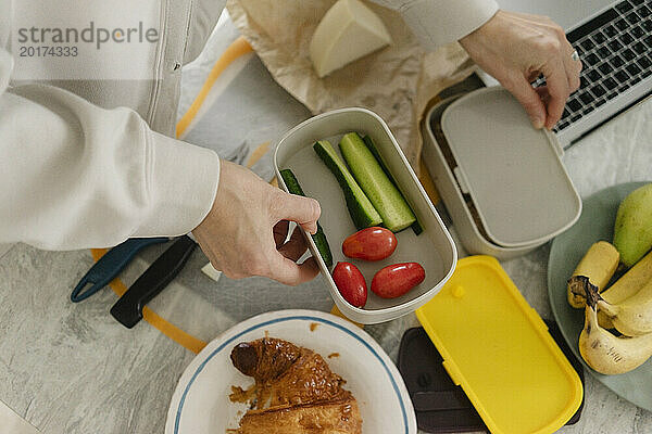 Woman preparing lunch boxes at home