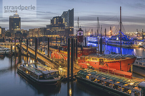 Deutschland  Hamburg  Boote liegen in der Abenddämmerung im Hafen  im Hintergrund die Elbphilharmonie