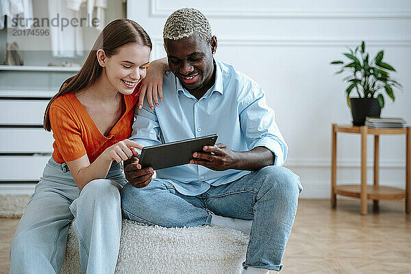 Glückliches junges Paar nutzt Tablet-PC zu Hause