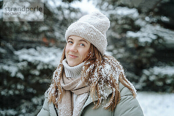 Lächelnde Frau mit Strickmütze im Winter im Schnee