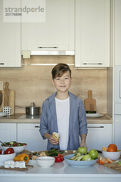 Smiling boy standing in kitchen at home